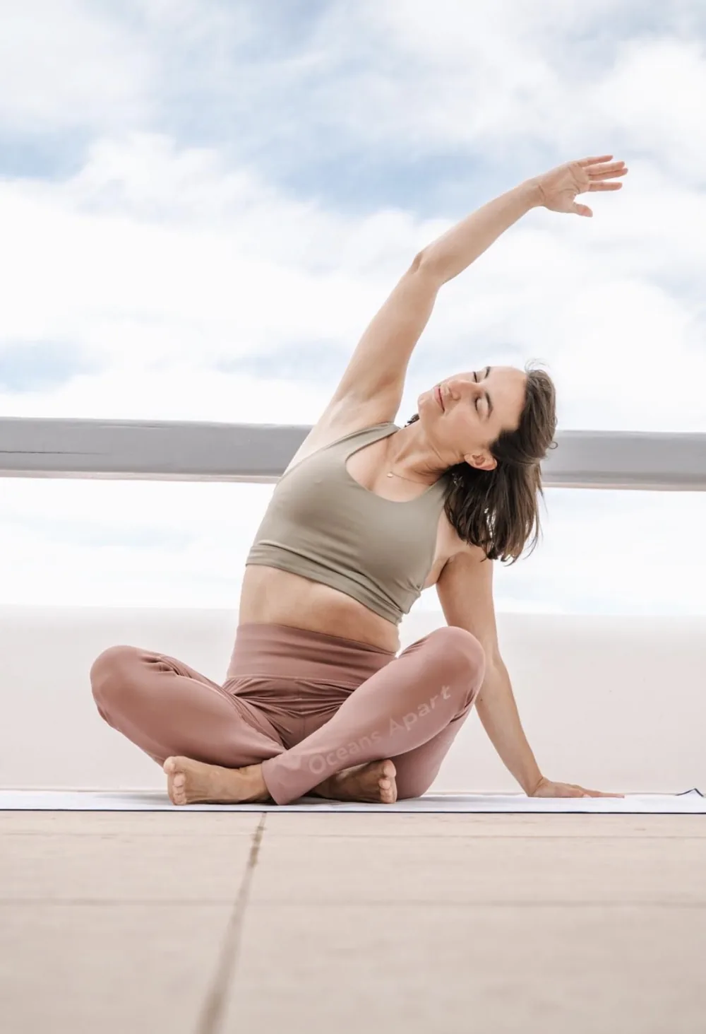 Blandine en posture de yoga assise, flexion latérale bras levé